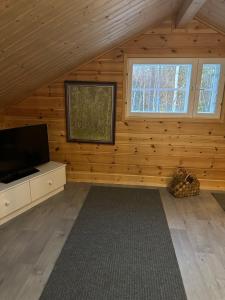 a room with a flat screen tv in a log cabin at Villa Länsitaalo in Kittilä