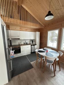 a kitchen with white cabinets and a table and chairs at Villa Länsitaalo in Kittilä