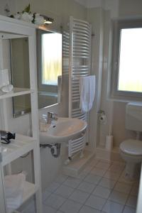 a white bathroom with a sink and a toilet at Münstermann in Garding
