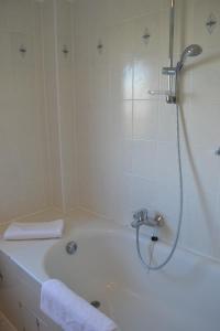 a bathroom with a shower and a bath tub at Münstermann in Garding +12 photos