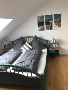 a bed in a room with two pictures on the wall at Münstermann in Garding