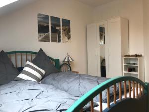 a bedroom with a bed with a green headboard at Münstermann in Garding
