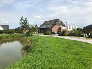 a house in a suburb with a pond at Münstermann in Garding
