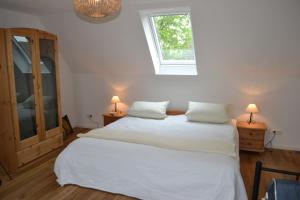 ein Schlafzimmer mit einem großen weißen Bett mit zwei Lampen in der Unterkunft Carlotta Haupthaus in Osterhever