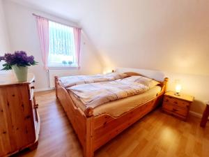 a bedroom with a large wooden bed with a window at Am Seedeich in Vollerwiek