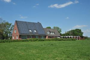 Vollerwiek的住宿－Am Seedeich，顶部设有太阳能电池板的房子