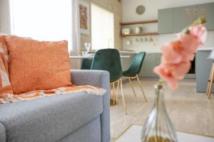 ein Wohnzimmer mit einem grauen Sofa und grünen Stühlen in der Unterkunft Luxurious 1BR home in Sliema Tigne, with pool by 360 Estates in Sliema