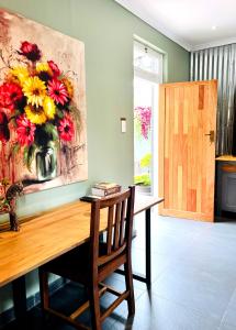 une table à manger avec un vase de fleurs sur le mur dans l'établissement Terebinte Bed & Breakfast, à Durban