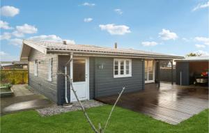 a grey house with a deck and a yard at 2 Bedroom Stunning Home In Karrebksminde in Karrebæksminde