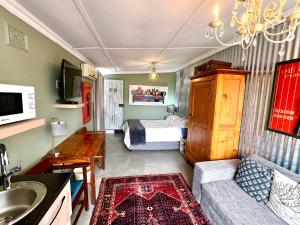 a small living room with a bed and a couch at Terebinte Bed & Breakfast - Durban in Durban