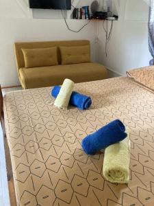 1 cama con almohadas azules y blancas y sofá en Bungalow Ti Papiyon en Bouillante