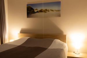 een slaapkamer met een bed en een schilderij aan de muur bij Appartement Nieuwpoort-Bad met garage in Nieuwpoort