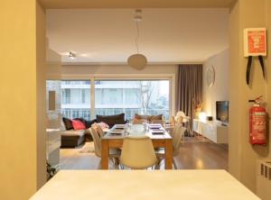 een eetkamer en een woonkamer met een tafel en stoelen bij Appartement Nieuwpoort-Bad met garage in Nieuwpoort