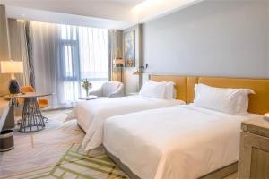 a hotel room with two beds and a table at Argyle Grand Hotel Nairobi Airport in Nairobi