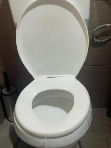 - des toilettes blanches avec un couvercle dans la salle de bains dans l'établissement Villa Ingracia" Rustig omgeving waar je wakker wordt van de mooie vogelgeluiden", à Paramaribo