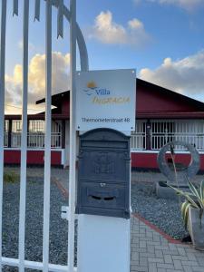 une porte avec un panneau devant un bâtiment dans l'établissement Villa Ingracia" Rustig omgeving waar je wakker wordt van de mooie vogelgeluiden", à Paramaribo