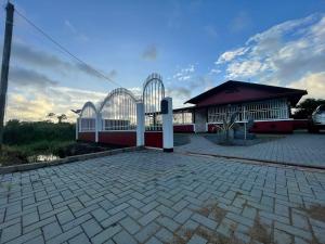 een gebouw met een poort en een bakstenen patio bij Villa Ingracia" Rustig omgeving waar je wakker wordt van de mooie vogelgeluiden" in Paramaribo