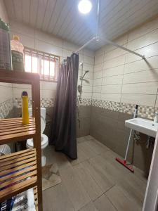 a bathroom with a shower and a toilet and a sink at Villa Ingracia" Rustig omgeving waar je wakker wordt van de mooie vogelgeluiden" in Paramaribo