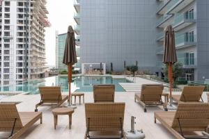 a patio with chairs and umbrellas next to a pool at Luxury Hotel Apartment - DownTown in Dubai