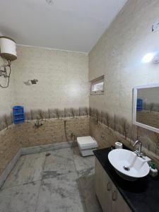een badkamer met een wastafel en een toilet bij Sunrise by Namastexplorer in Bhīm Tāl