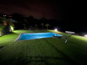 a swimming pool in a yard at night at Appartement Bois Banane in Lamentin