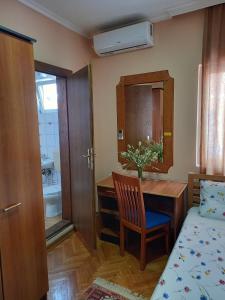 a bedroom with a table and a bed and a bathroom at Hotel Peja in Peje