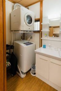 a bathroom with a sink and a washing machine at HAT京終、京終駅徒歩４分。奈良公園・奈良町へ行くのにおすすめ！ in Mitsugarasuchō