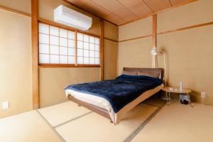 a bedroom with a bed in a room with a window at HAT京終、京終駅徒歩４分。奈良公園・奈良町へ行くのにおすすめ！ in Mitsugarasuchō