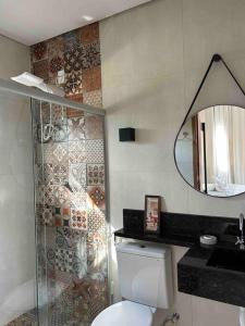 a bathroom with a toilet and a mirror at Flat Jade - Alto Paraíso - Chapada dos Veadeiros in Alto Paraíso de Goiás