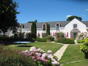 une maison avec un jardin fleuri dans la cour dans l'établissement Gîte 3 avec piscine - plage 3kms, à Clohars-Carnoët