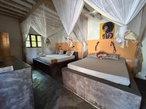 a bedroom with two beds and a painting on the wall at Bahari Beach Bungalows in Jambiani