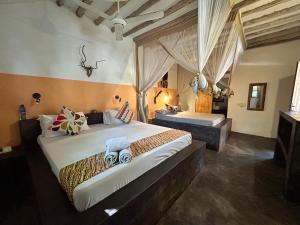 1 dormitorio con 2 camas y lavamanos. en Bahari Beach Bungalows en Jambiani