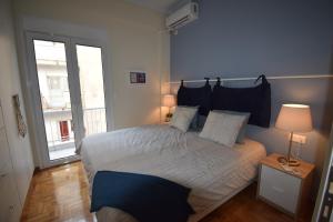 a bedroom with a bed and a large window at Piraeus Blue in Piraeus