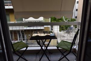 a balcony with two chairs and a table on a balcony at Piraeus Blue in Piraeus