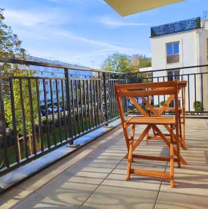 a wooden chair sitting on a balcony at Chambre privée dans un nouvel appartement partagé près de Paris avec parking gratuit in Chevilly-Larue