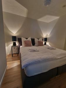 a bedroom with a large bed with two lamps at Argenta Living 42 in Künzell
