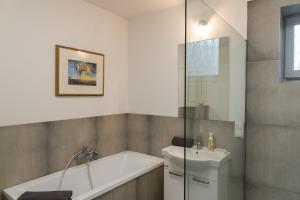 a bathroom with a bath tub and a sink at VacationClub - Nadrzeczna VacationHome 1 in Ustroń