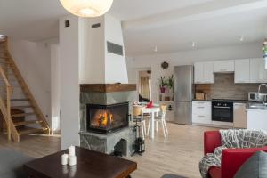 a living room with a fireplace and a kitchen at VacationClub - Nadrzeczna VacationHome 1 in Ustroń