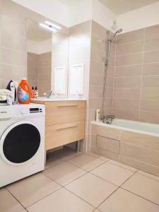 a bathroom with a washing machine and a bath tub at Chambre privée dans un nouvel appartement partagé près de Paris avec parking gratuit in Chevilly-Larue