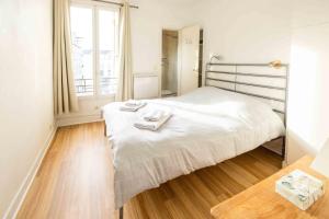 ein Schlafzimmer mit einem Bett mit zwei Handtüchern darauf in der Unterkunft Well located apartment in Paris in Paris