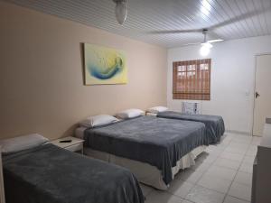 a bedroom with two beds and a window at Pousada Areias Brancas in Búzios