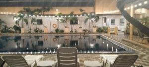 a pool in a building with chairs around it at Tèja Hotel in Bangkok