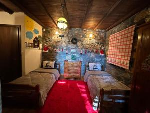 1 dormitorio con 2 camas y pared de piedra en Blessings Chalet στον Παλαιό Άγιο Αθανάσιο με Τζάκι, Barbeque, μεγάλη αυλή και υπέροχη θέα en Palaios Agios Athanasios