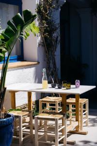 a wooden table and chairs with a white table and a table at Hotel Casa Nereta in Cadaqués