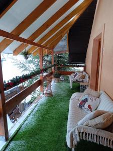 a patio with green grass and couches under a roof at Privát Majo in Liptovský Mikuláš