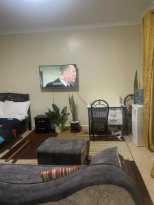 a living room with a couch and a tv on the wall at Zuhura homes in Ruiru