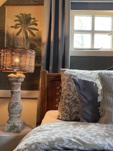 een slaapkamer met een bed met een lamp en een raam bij Vakantie-Appartement WedderheideHoeve in Wedde