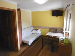 um pequeno quarto com uma cama, uma mesa e cadeiras em Agroturystyka Szalejów 117 em Szalejów Górny