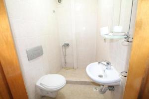 a white bathroom with a toilet and a sink at erciyes suites in Istanbul
