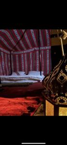 a bedroom with a bed with a red and white canopy at Dubaicanam Camp in Dubai